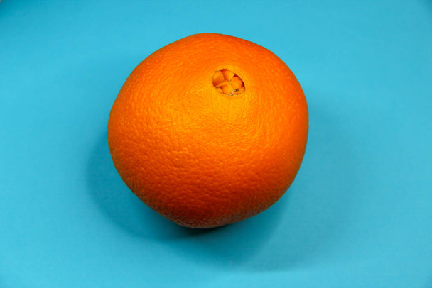 Gros fruit orange sur fond bleu - Photo, image