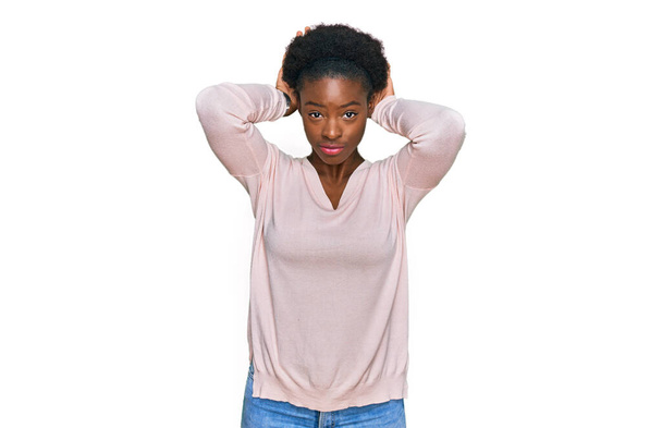 Nuori afrikkalainen amerikkalainen tyttö yllään rento vaatteita tekemässä pupu korvat ele kädet kämmenet näköinen kyyninen ja skeptinen. pääsiäiskanin käsite.  - Valokuva, kuva