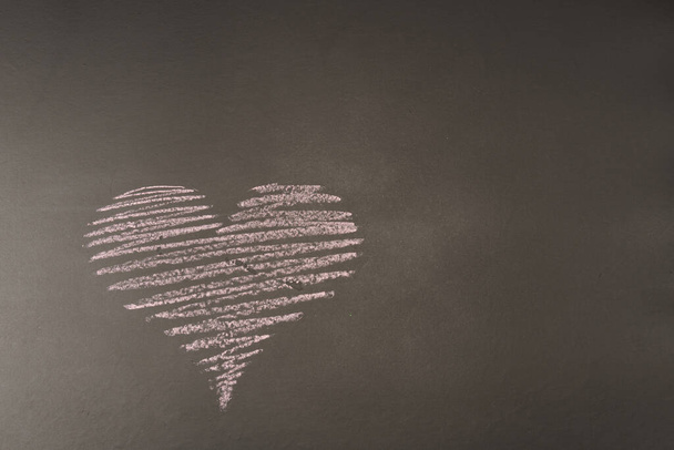 Siyah arka planda tebeşirle çizilmiş bir kalp, yazı için bir yer. Valentine kartı. - Fotoğraf, Görsel