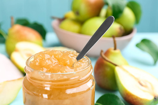 Tasty homemade pear jam and fresh fruits on light blue table, closeup - Foto, afbeelding