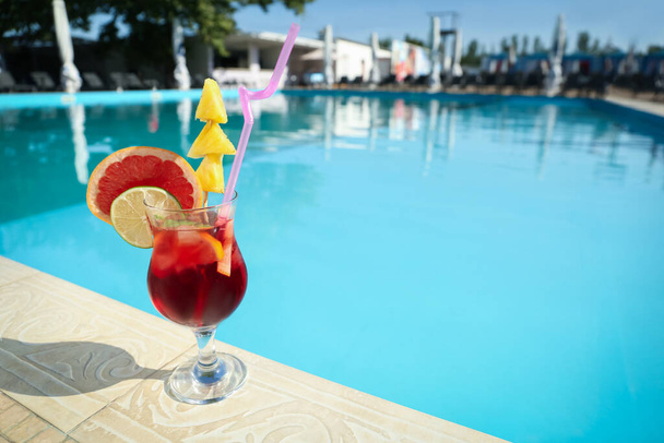 Tasty refreshing cocktail on edge of swimming pool. Party drink - Foto, Bild