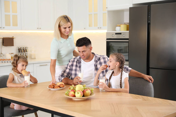 Happy family eating together at table in modern kitchen - Foto, Imagem