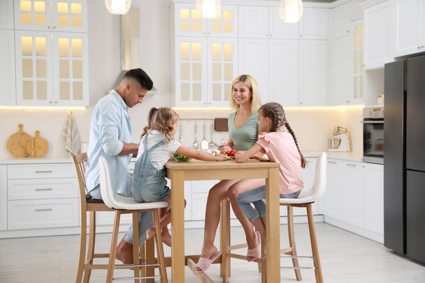 Happy family cooking together at table in modern kitchen - Photo, Image