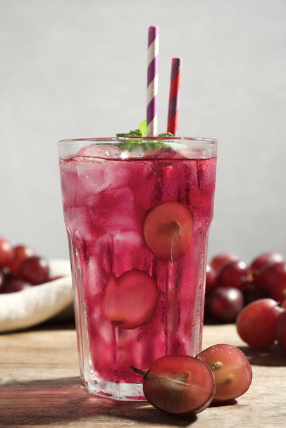 Delicious grape soda water with mint and berries on wooden table. Refreshing drink - Фото, изображение