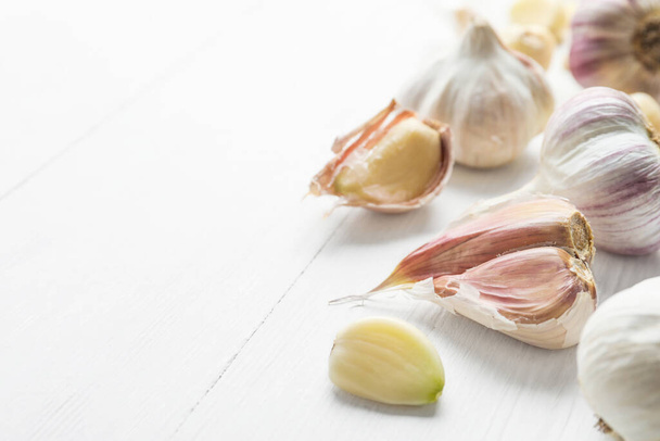 Fresh organic garlic on white wooden table, closeup. Space for text - Foto, Imagen