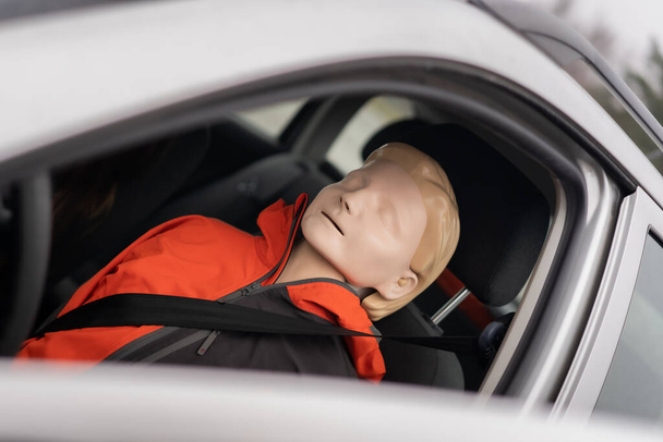 Resuscitation model is sitting on the seat of the driver ready for another medical simulation during professional first aid course - Photo, Image
