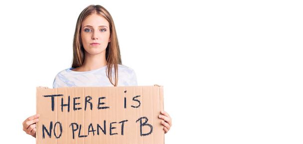 Young beautiful blonde woman holding there is no planet b banner thinking attitude and sober expression looking self confident  - Photo, Image