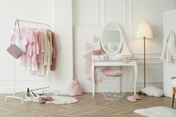 Dressing room interior with clothing rack and round mirror - Φωτογραφία, εικόνα