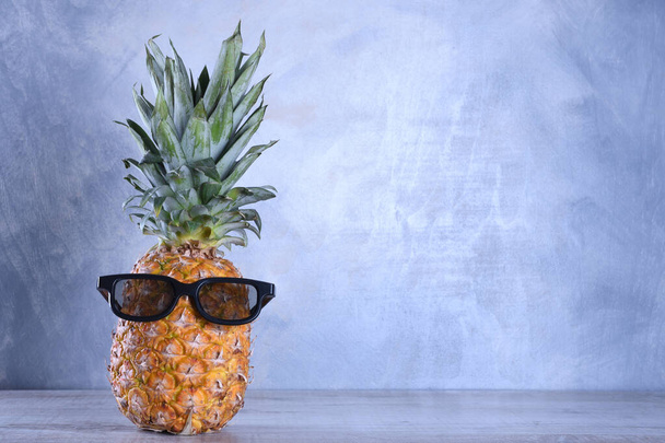 Ahşap bir arka planda gözlüklü ananas.. - Fotoğraf, Görsel