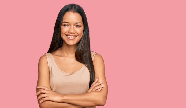 Beautiful hispanic woman wearing casual clothes happy face smiling with crossed arms looking at the camera. positive person.  - Фото, изображение