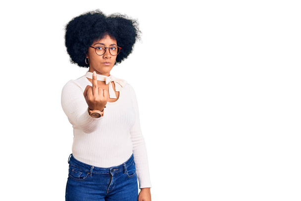 юна афро-американська дівчина в повсякденному одязі і окулярах, показуючи середній палець, неввічливий і грубий відвали від виразу  - Фото, зображення