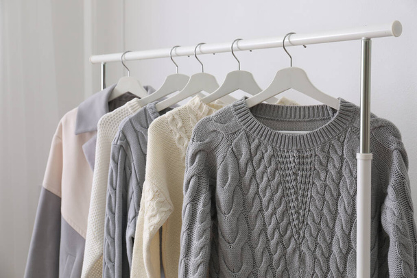 Rack with stylish warm clothes indoors, closeup - Foto, imagen