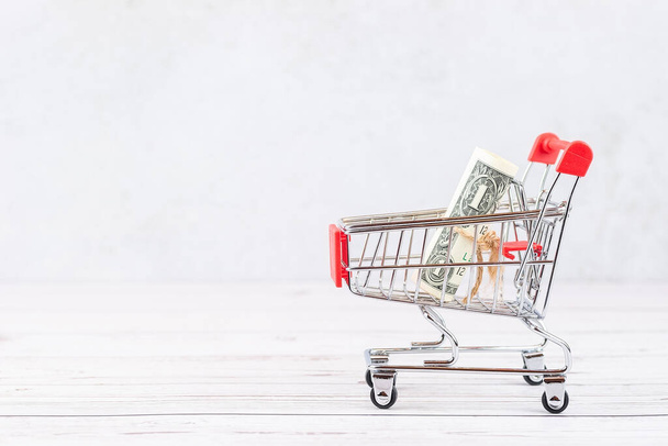 Financial concept, bank notes in the shopping cart. shopping cart with dollars banknotes. financial concept. Dollar in the basket - Foto, Imagem
