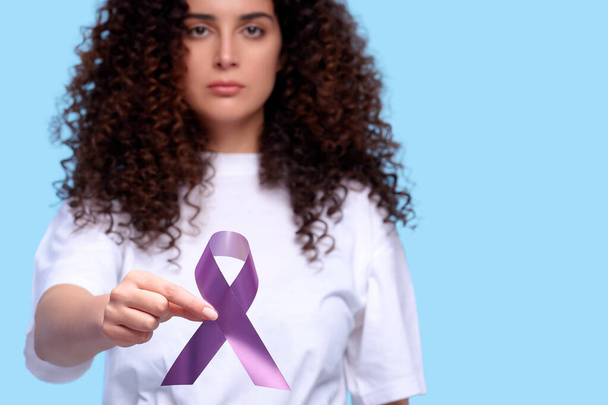 女性は紫色のリボン意識のコピースペースを保持する。隔離された背景の癌のシンボル - 写真・画像