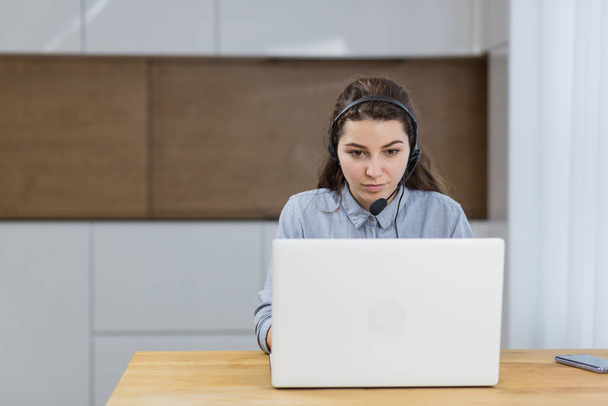 Woman talking on a headset through a laptop - Fotoğraf, Görsel
