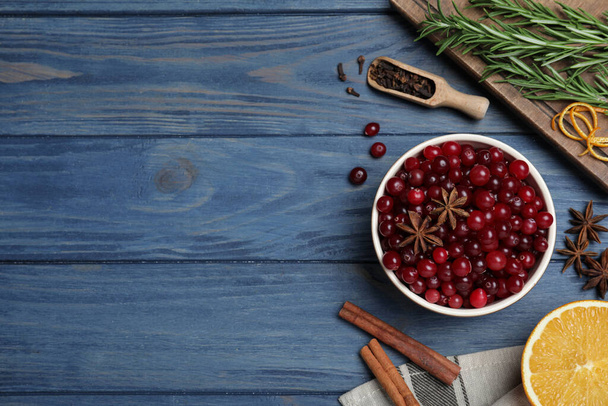 Επίπεδη σύνθεση με φρέσκα ώριμα cranberries σε μπλε ξύλινο τραπέζι. Χώρος για κείμενο - Φωτογραφία, εικόνα