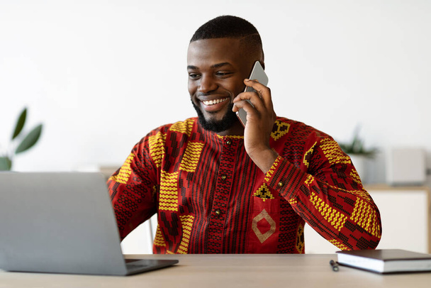 Karriere aus der Ferne. Junger afrikanischer Freiberufler telefoniert im Home Office - Foto, Bild
