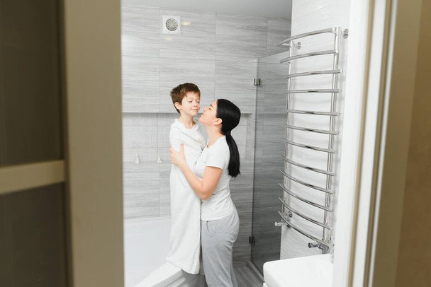 Mother washing little son in bathroom - Foto, afbeelding