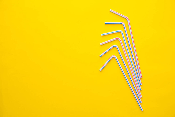 Drinking plastic straws on a yellow background. Colorful of plastic straws used for drinking water or soft drinks. Top view. Minimalist Style. Copy, empty space for text. - Zdjęcie, obraz