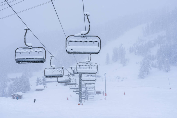 Empty ski slopes and ski lifts in Auron ski resort, France. During the winter holidays of 2020 December and 2021 January lifts are closed for skiing for adults during to the coronavirus pandemic.  - Foto, Imagen