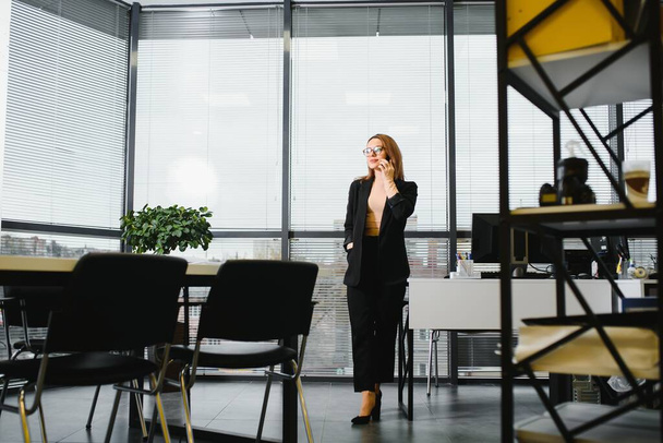Confident business woman stands in the office - Fotó, kép