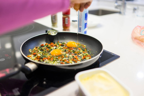In the course of making breakfast with fresh eggs and vegetables - Foto, immagini