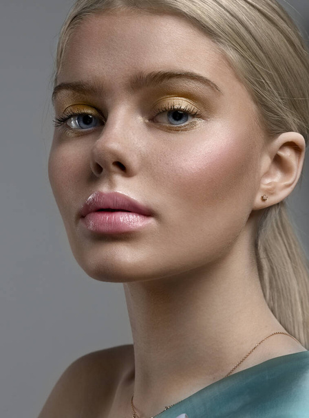 Close-up portrait of a girl. Woman's face. Clean skin. Blonde hair. Plump lips. Small earring in the ear. - Fotoğraf, Görsel