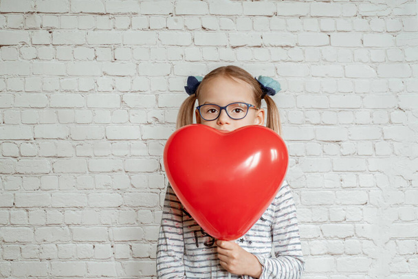 Κοριτσάκι με κόκκινη καρδιά σε σχήμα baloon, Ημέρα του Αγίου Βαλεντίνου φόντο - Φωτογραφία, εικόνα