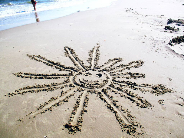 Helder stralende zon getrokken op het zand, familie roepingen  - Foto, afbeelding
