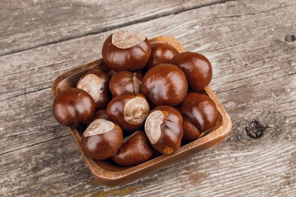 Chestnuts on an old wooden table. - Photo, Image