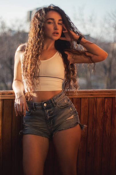 beautiful girl with curls in shorts - Photo, Image