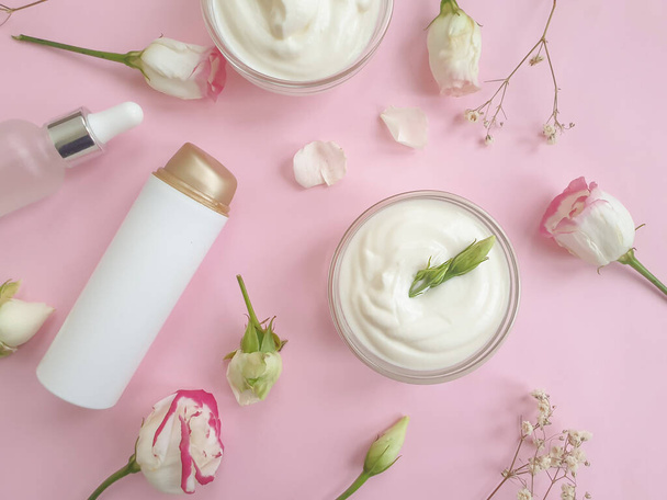 cosmetische crème, roos bloem op een gekleurde achtergrond - Foto, afbeelding