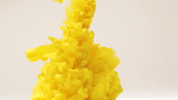 Abstraktní pozadí cákanců žluté barvy ve vodě, výbuch žluté barvy, cákání a šíření jasných barev - Záběry, video