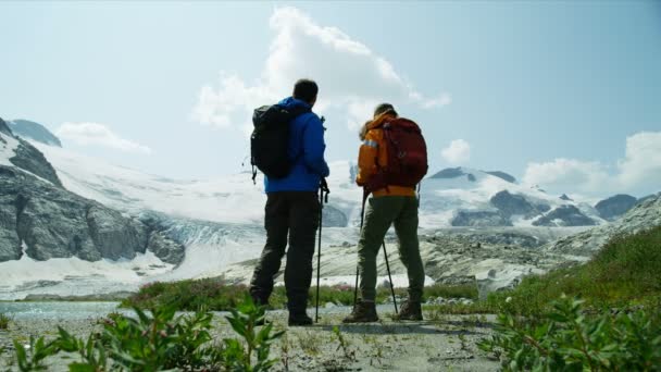 Výhled na jezero Heli hikers samec samice mladé kavkazské travelers hiking in snow covered mountains near ice glacier Canada   - Záběry, video