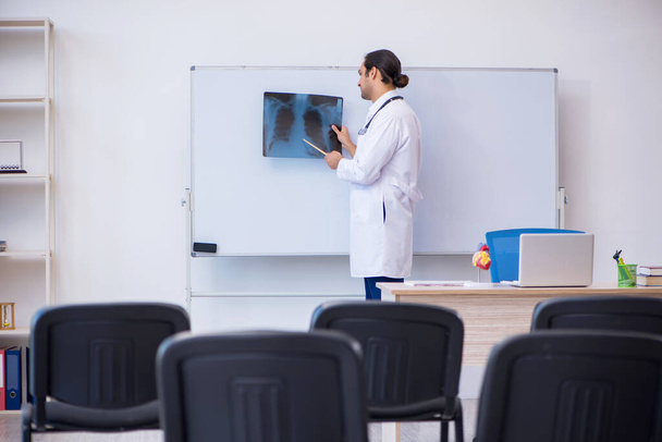 Hombre joven radiólogo médico dando seminario en el aula - Foto, imagen