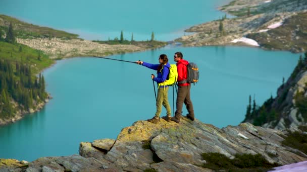Lake view Heli hikers male female young Caucasian travelers hiking in scenic mountains near glacier Canada   - Footage, Video