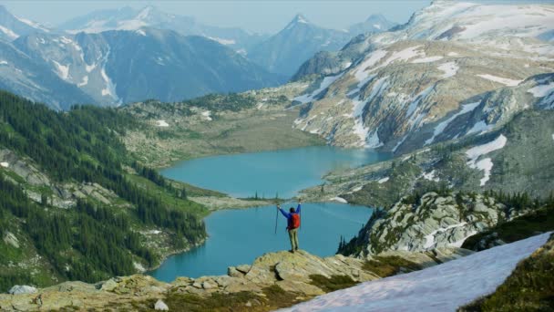 Aktywny wypoczynek dla kobiet wędrówki w ekstremalnych wysokich terenach górskich relaks na krawędzi urwiska w pobliżu jeziora lodowcowego Kolumbia Brytyjska   - Materiał filmowy, wideo