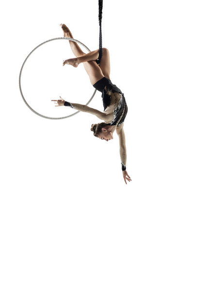Young female acrobat, circus athlete isolated on white studio background. Training perfect balanced in flight - Foto, Imagem