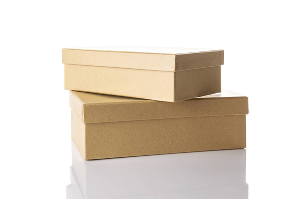 Переработка коробки. Бурый картонный пакет для доставки грузов изолирован на белом фоне. Макет закрытого бумажного объекта для проектирования - Фото, изображение