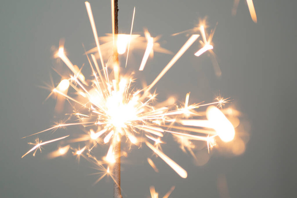Sparkler lit burning down on a gray background  - Photo, Image