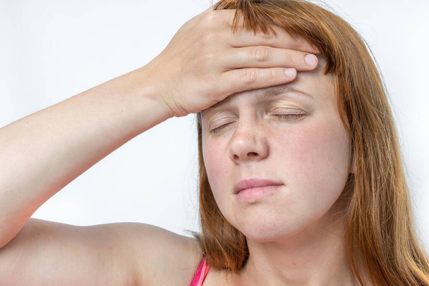 Žena s bolestí hlavy nebo migrénou drží své bolavé čelo - tělo koncepce bolesti - Fotografie, Obrázek