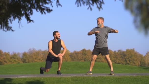 De twee gelukkige mannen stretching outdoor - Video