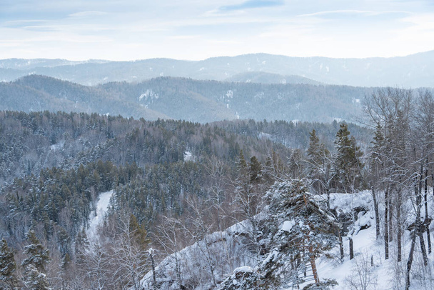 A szelíd hegyeket hóerdő borítja. Kilátás a hegyi völgyre télen - Fotó, kép