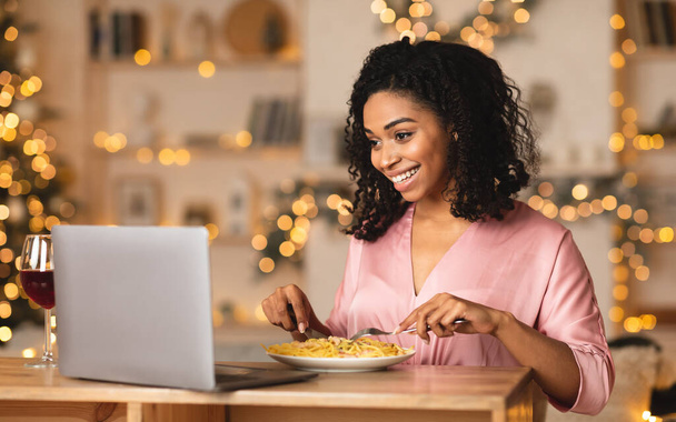 Musta nainen ottaa illallisen aikana virtuaalinen päivämäärä kannettavan - Valokuva, kuva