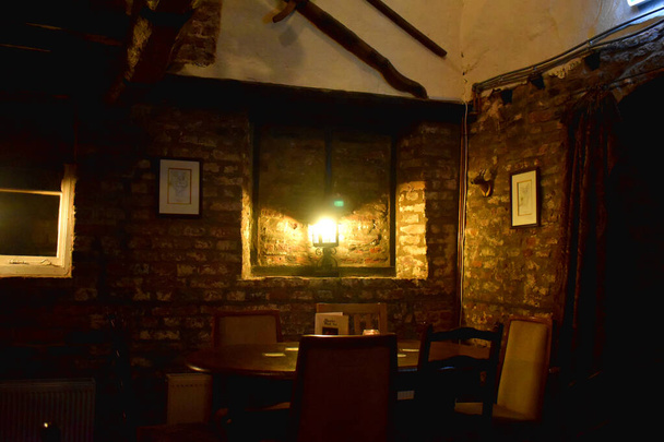 レンガ造りの部屋の建物内のランプから輝く光、古いスタイルで装飾 - 写真・画像