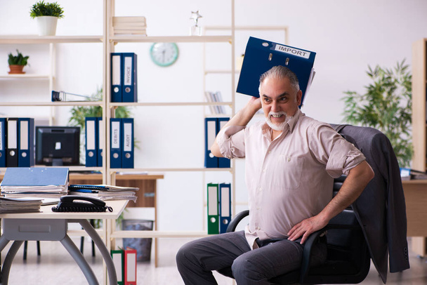 Viejo empleado haciendo ejercicios físicos en el lugar de trabajo - Foto, Imagen