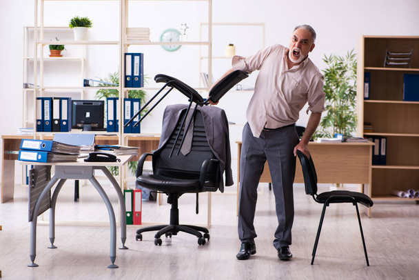 Vecchio dipendente maschio che fa esercizi fisici sul posto di lavoro - Foto, immagini