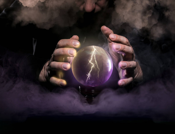 Fortune teller with crystal ball on dark background, closeup - Photo, Image