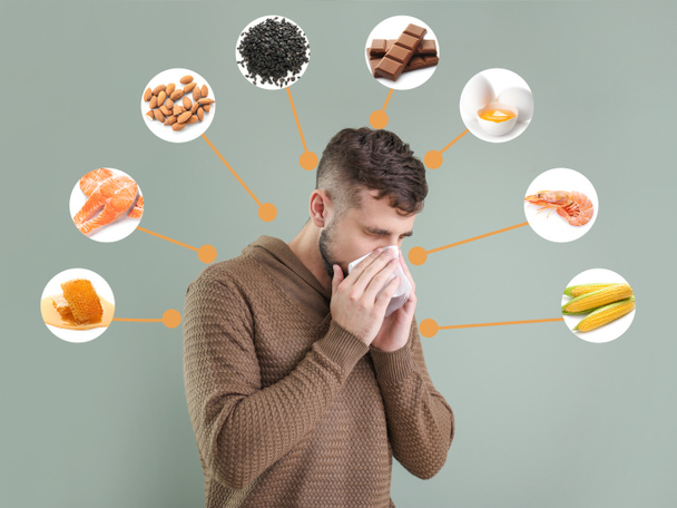 灰色の背景に食物アレルギーを患っている若い男 - 写真・画像