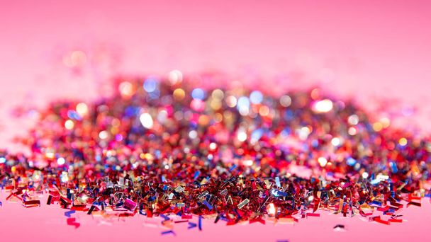 Close-up de um monte de confetes brilhantes sobre fundo rosa. Carnaval e conceito de festa. Fotografia vertical. Espaço de cópia - Foto, Imagem